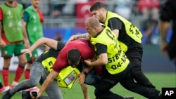 Redari zaustavljaju navijača na terenu tokom utakmice grupe F između Turske i Portugala na Euru 2024 u Dortmundu, Njemačka, 22. juna 2024.