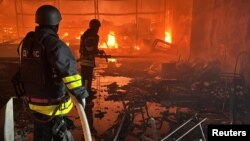Ukrainian firefighters battle a blaze at a shopping mall hit by a Russian air strike in Kharkiv on May 25.
