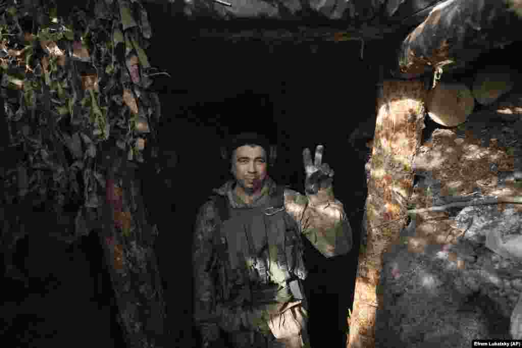 Украински војник го покажува знакот за победа од својата позиција во ровот во близина на Клишчијивка. Киев вети дека ќе ја врати целата земја окупирана од Русија, вклучувајќи го и Кримскиот Полуостров, кој Кремљ незаконски го анектираше од Украина во 2014 година. &nbsp;