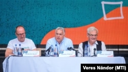 Orbán Viktor miniszterelnök (k) előadást tart a Tusnádfürdőn 2024. július 27-én. Mellette Németh Zsolt, az Országgyűlés külügyi bizottságának fideszes elnöke (b) és Tőkés László, az Erdélyi Magyar Nemzeti Tanács (EMNT) elnöke (j)