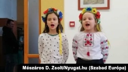 Ukrán menekült kislányok énekelnek a szombathelyi Litera menekülteket segítő egyesület rendezvényén