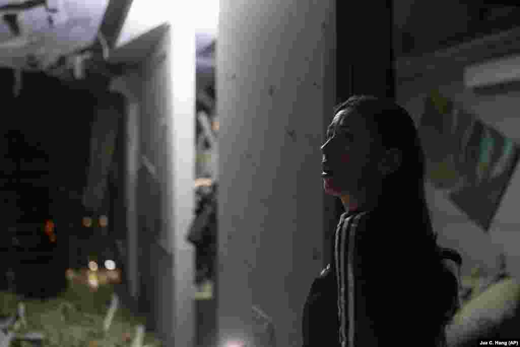 A resident surveys her neighbor&#39;s apartment that was damaged during the drone attack.