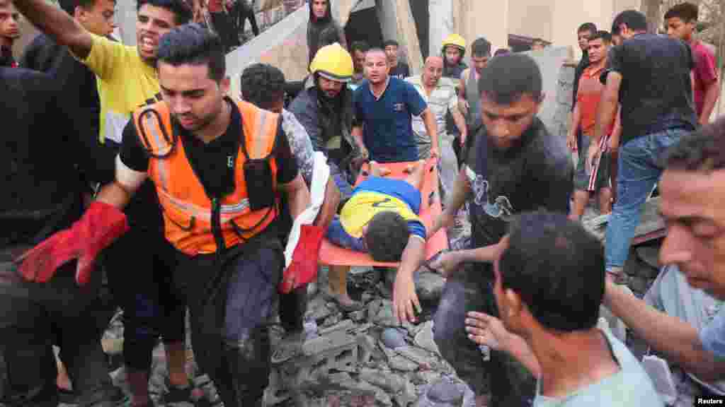 Helyiek kiemelnek egy sérültet egy izraeli csapások által lerombolt ház romjai alól a Gázai övezet déli részén fekvő Hán Júniszban 2023. október 17-én. Az izraeli hadsereg 1,1 millió embert szólított fel arra, hogy hagyja el a sűrűn lakott Gáza északi részét, beleértve Gázavárost, és költözzön az enklávé déli részére.&nbsp;Sok család, akik közül néhányan már korábban is belső menekültek voltak, most még kisebb területen kénytelen összezsúfolódni