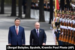 Президент Китая Си Цзиньпин (слева) и руководитель России Путин идут мимо почетного караула в Пекине. Китай, 2024 год