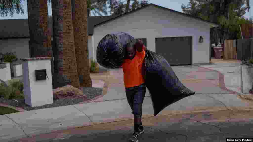 Ulises, egy mexikói kertépítő levelekkel teli zsákokat cipel a huszonhetedik napja tartó hőhullám alatt az arizonai Phoenixben 2023. július 27-én.&nbsp;Ezekben a napokban a hőmérséklet meghaladta a 43 Celsius-fokot &nbsp;