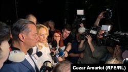 Gabriela Firea și primarul sectorului 4, Daniel Băluță, părăsesc incinta PSD, în mijlocul câtorva zeci de jurnaliști. Drumul de un sfert de oră până la poartă a fost un lung șir de întrebări adresate Gabrielei Firea referitor la eșecul înregistrat la Primăria Capitalei