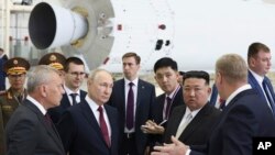 Ruski predsednik Vladimir Putin i lider Severne Koreje Kim Džong Un obilaze hangar za raketne sklopove tokom svog sastanka na kosmodromu Vostočni u dalekoistočnom ruskom Amurskom regionu, 13. septembra 2023.