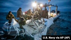 Na ovoj fotografiji koju je je ustupila Mornarica SAD-a, mornari dodijeljeni Grupi za uklanjanje eksplozivnih naprava pronalaze balon za nadzor kod obale Myrtle Beacha, Južna Karolina, 5. februara 2023.