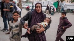 Palestinka sa djecom ispred bolnice nakon izraelskog bombardovanja u Bureiju, centralo područje Pojasa Gaze, 8. aprila 2024.