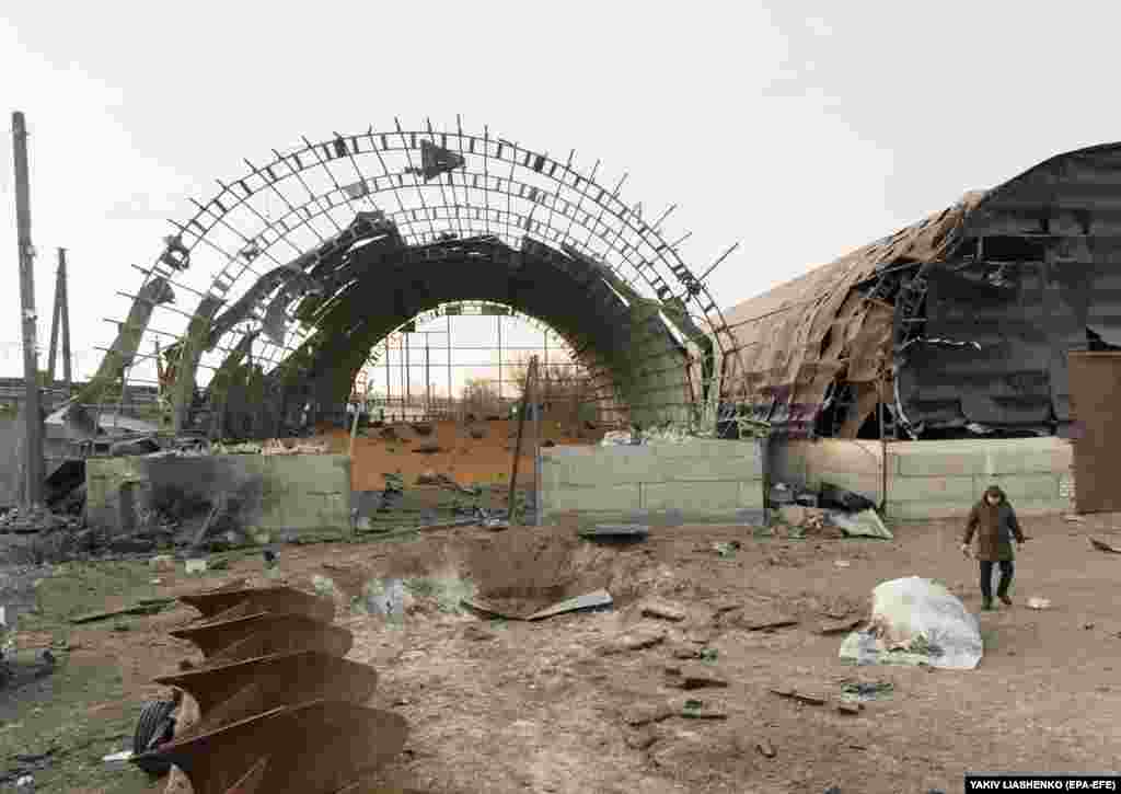 Mještani hodaju pored oštećenog silosa za skladištenje žita, nakon noćnog raketnog napada na Pisočin, nedaleko od Harkiva na sjeveroistoku Ukrajine.