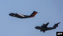 Два военни самолета Airbus A400M на германските въоръжени сили се приближават към във военновъздушната база във Вунсторф, Северна Германия