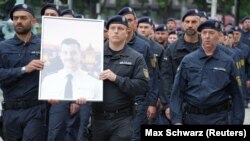 Polițiști germani cu un portret al colegului lor Rouven Laur, ucis cu cuțitul de un azilant afgan pe 31 mai la Mannheim.