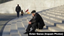 Un bătrân se uită după o mamă care își ține copilul de mână. Câte dintre șansele la educație și sănătate ale celui mic au fost influențate de votul celor doi adulți? Vor merge duminică la vot? Tu te-ai hotărât pe cine vei alege ? 