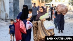 Gra palestineze me fëmijë e të ngarkuara me gjësende teksa ikin nga zona si pasojë e një sulmi ajror izraelit në Rafah, në Rripin jugor të Gazës, më 13 tetor 2023.