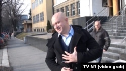 Zvonko Veselinović i Milan Radoičić (iza) isped Specijalnog suda u Beogradu gde im je suđeno za prisvajanje kamiona "Hipo Alpe Adria Lizinga", 9. februar 2015.