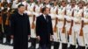 Președintele francez Emmanuel Macron (centru) și președintele chinez Xi Jinping, salută garda de onoare în timpul unei ceremonii de bun venit, în fața Marii Săli a Poporului din Beijing, noiembrie 2019.