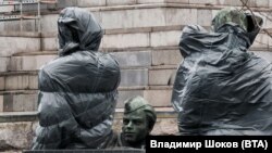 Опакованите за транспортиране фигури от паметника.