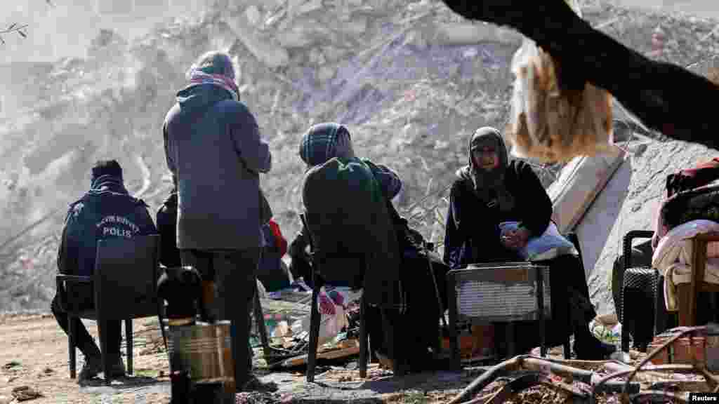 Антакия қаласында қирап қалған үйдің жанында отырған тұрғындар. 16 ақпан, 2023 жыл.&nbsp;