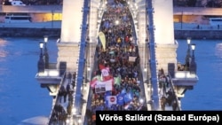 Tüntetők vonulnak át a Lánchídon a Sándor-palota felé 2024. február 9-én, követelve Novák Katalin köztársasági elnök lemondását