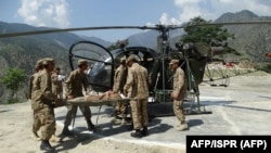 Pakistani Army personnel evacuate a resident injured in flooding in Chitral. (file photo)