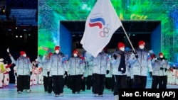 Olga Fatkulina and Vadim Shipachyov of the Russian Olympic Committee carry a flag into the stadium during the opening ceremony of the 2022 Winter Olympics, on February 4, 2022, in Beijing.