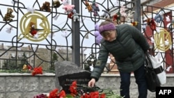 Жена положува цвеќе на споменикот во близина на железничката станица во Краматорск, во регионот Доњецк, 8 април 2023 година