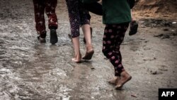 Палестинските деца одат по каллива патека во импровизиран камп за раселените Палестинци, во Рафах во јужниот дел на Појасот Газа, во услови на судири меѓу Израел и милитантната група Хамас, на 2 јануари 2024 година.