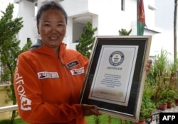 Лакпа Шерпа държи сертификата си от Гинес за най-много успешни изкачвания на Еверест, направени от жена, Катманду, 27 май 2016 г.