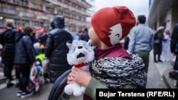 Dijete gleda kako se volonteri spuštaju u Pedijatrijsku kliniku nakon što je dobio na poklon igračku.