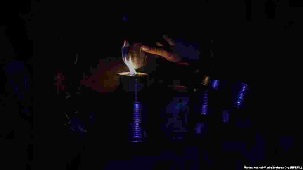 Egy katona gyertyát gyújt, ami ilyenkor az egyetlen hő- és fényforrás a lövészárokban