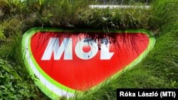 A természetközeliséget szimbolizálva növények között a Mol céglogója egy budapesti benzinkúton 2022. július 17-én