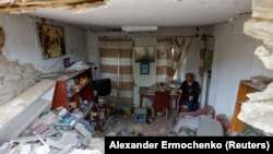 Un locuitor din regiunea Donețk privește descumpănit dezastrul lăsat în urmă de bombardamentele Rusiei.