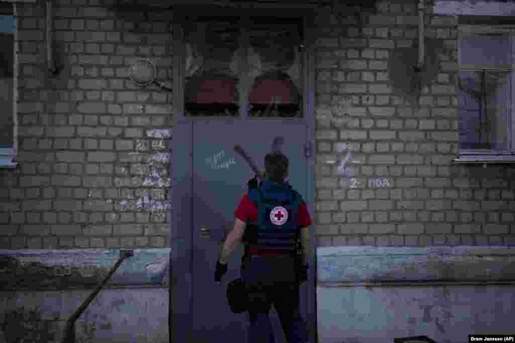 Az ukrán Vöröskereszt munkatársa megpróbál bejutni egy lakóépületbe, amelyre az orosz hadsereg jelképe, a Z betű van festve. Kupjanszk egykor orosz ellenőrzés alatt állt, de az ukránok 2022 szeptemberében visszafoglalták