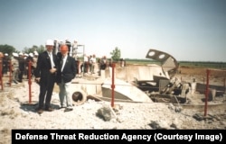 Ljudi u grupi gledaju ostatke uništenog silosa nuklearnog projektila u Ukrajini.