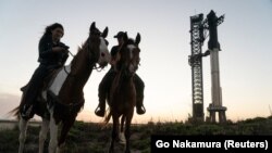 Барбара Белвиси и Џин Гор јаваат коњи додека Ѕвездениот брод на SpaceX се гледа на неговата лансирна рампа во Бока Чика, откако Федералната управа за авијација на САД ја додели долгоочекуваната лиценца со која му дозволи на SpaceX на Илон Маск да ја лансира ракетата во орбитата. 