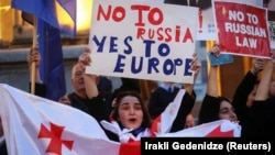 Жени държат плакати с надписи "Не на Русия, да на Европа" и "Не на руския закон", Тбилиси, 15 април 2024 г.