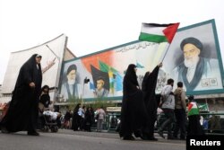 ირანელ ქალს უჭირავს პალესტინის დროშა პალესტინელების მხარდასაჭერი მიტინგის დროს თეირანში. ირანი, 2023 წლის 13 ოქტომბერი.