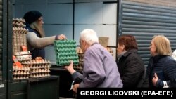 Disa qytetarë duke blerë vezë në tregun e gjelbër në Shkup më 5 prill 2023.
