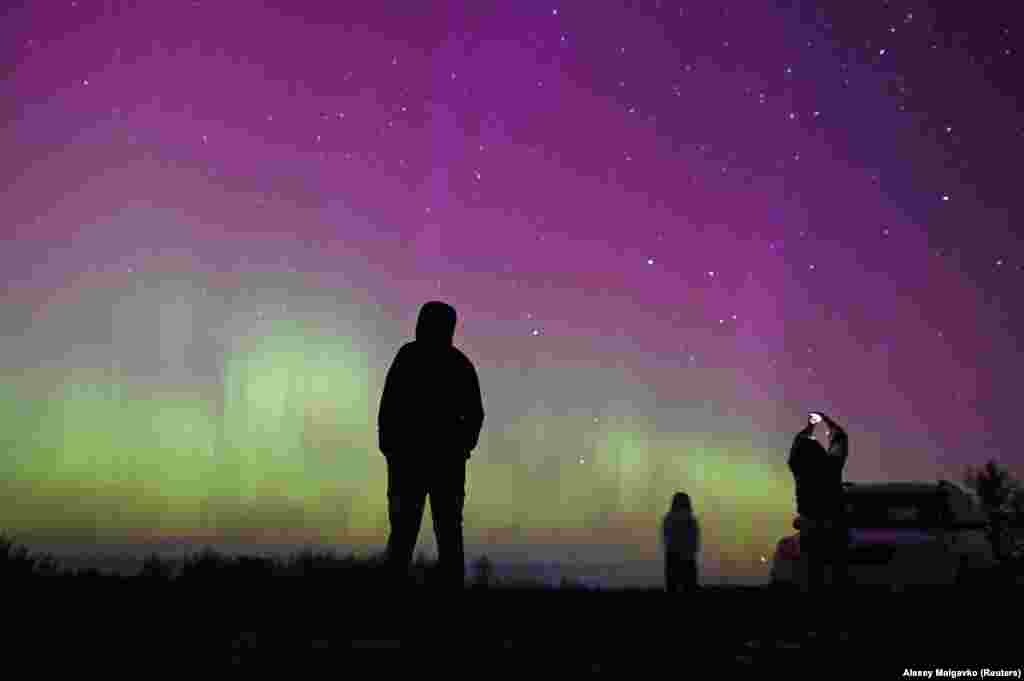  Severna svetlost osvetljava nebo iznad ljudi okupljenih da posmatraju kišu meteora Perseide u blizu sela Borodinka u ruskoj Omskoj oblasti. &nbsp; 