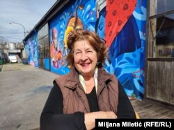 Danica Spremo ispred Dorćol Platza, okružena muralima sa ženskim likovima