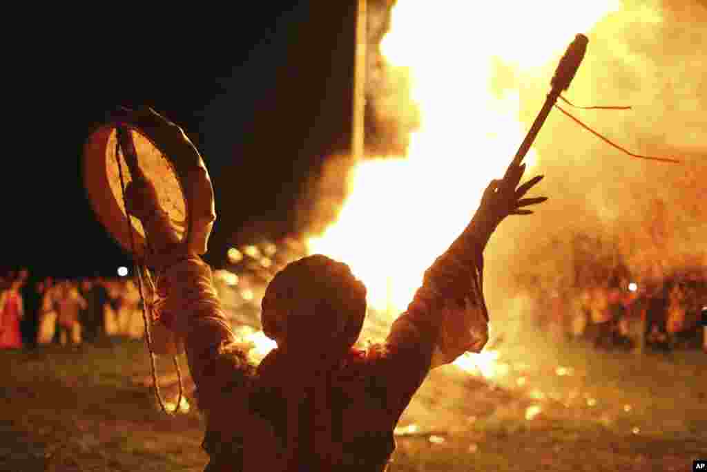 Osoba maše bubnjem dok drugi ljudi u tradicionalnoj ruskoj odjeći u seoskom stilu slave ljetnji solsticij u selu Okunevo, oko 200 kilometara (oko 125 milja) sjeveroistočno od sibirskog grada Omska, Rusija, u Okunevu, Rusija,&nbsp; 20.juna 2024.&nbsp;