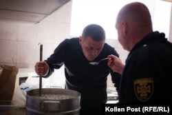 Andrij Talanov i Viktor Veretelnik probaju okrošku koju prave u glavnoj vatrogasnoj stanici u Harkivu.