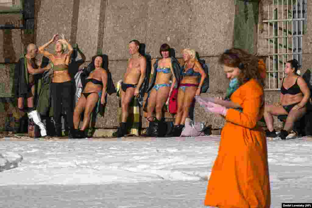 Băi de soare lângă zidul Fortăreței Petru și Pavel, pe malul râului Neva, în Sankt Petersburg, Rusia.