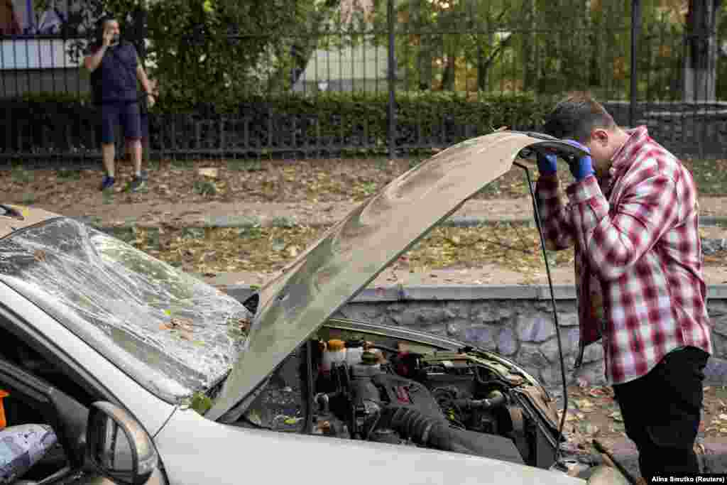 A Kyiv resident inspects his car, which was damaged during the missile attack.