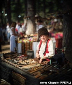 Egy férfi egy kézzel készített késeket árusító standnál