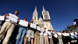 Aktivisti i aktivistkinje u Hrvatskoj ispred Zagrebačke katedrale nose imena žrtava u Ahmićima u znak protesta protiv dočeka Darija Kordića u zračnoj luci u Zagrebu, jun 2014. 