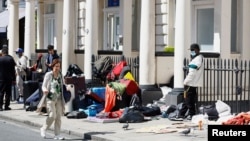 Navodni tražilac azila stoji ispred hotela u znak protesta zbog smještaja, London, Velika Britanija, 2. juni 2023. 