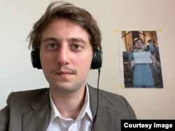 ნიკა რომანაძე სასამართლო სხდომებს დისტანციურად ესწრება. წინა სხდომაზე მოსამართლემ მას სთხოვა, ჩამოეხსნა კედელზე გაკრული საკუთარი ფოტო, რომელიც ამ საქმეში ადმინისტრაციული სამართალდარღვევის მტკიცებულებად არის წარმოდგენილი პოლიციის მხრიდან.