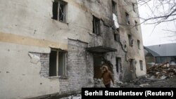 Një person kalon pranë një ndërtese banimi të dëmtuar nga një sulm rus me dronë. Odesa, 14 dhjetor 2023. 