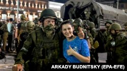 O tânără pozează cu un mercenar al grupării Wagner - cunoscută în Rusia ca o „companie militară privată” - înainte ca forțele de rebeliune să părăsească orașul Rostov pe Don, în sudul Rusiei, 24 iunie 2023.